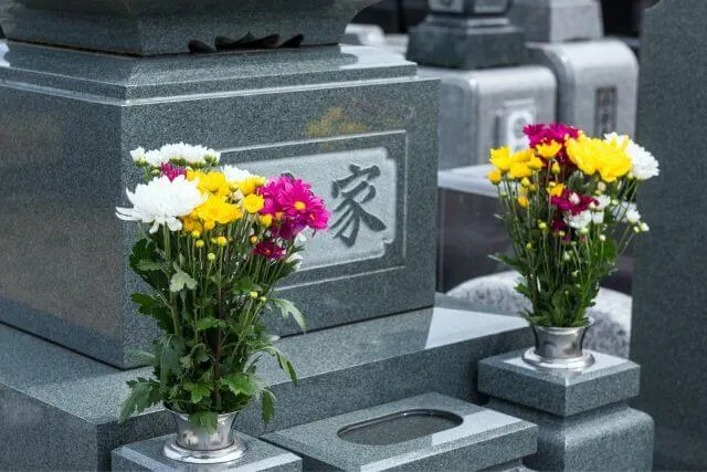 色とりどりの花が手向けられた墓石